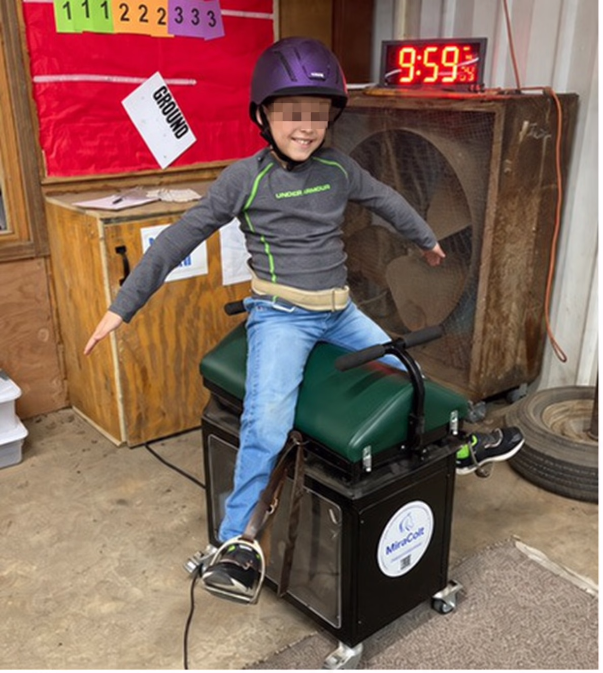 A helmeted participant on the MiraColt™ with arms extended during an activity.